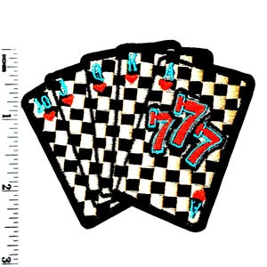 May include: Embroidered playing card patches featuring a black and white checkered pattern. The cards include a Jack, King, Ace, and a 777 design. Each card has red hearts and blue accents. The patches measure approximately 2.5 inches in height.