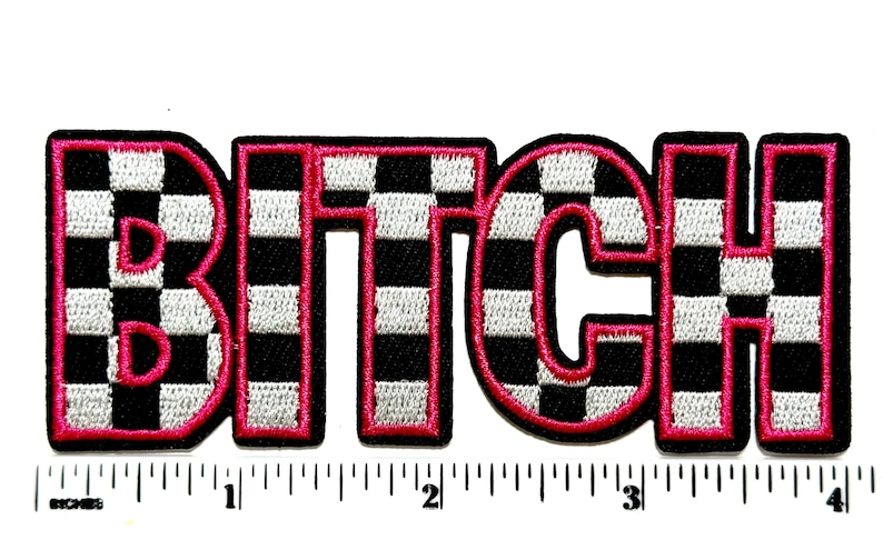 Pu&ograve; includere: Toppa ricamata con la parola "BITCH" a grandi lettere a blocchi. Le lettere sono a scacchi bianchi e neri con un contorno rosa acceso. La toppa &egrave; su sfondo bianco con un righello in pollici.