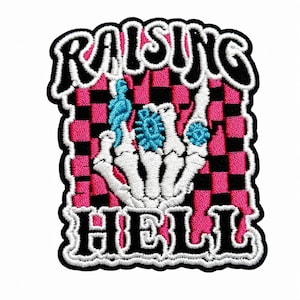 May include: An embroidered patch featuring a white skeleton hand making a rock-and-roll gesture against a pink and black checkered background. The text RAISING HELL is stitched in black with white outlines at the top and bottom of the patch.
