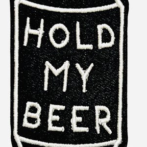 May include: Black and white embroidered patch in the shape of a beer can. The words "HOLD MY BEER" are stitched in white, with a white outline around the can. A fun accessory for jackets, bags, or hats.
