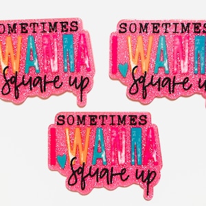 May include: Three pink glittery rectangular pins with the text "SOMETIMES I WANNA square up" in various colors. The pins have a heart shape on the left side. The text is in black cursive font.