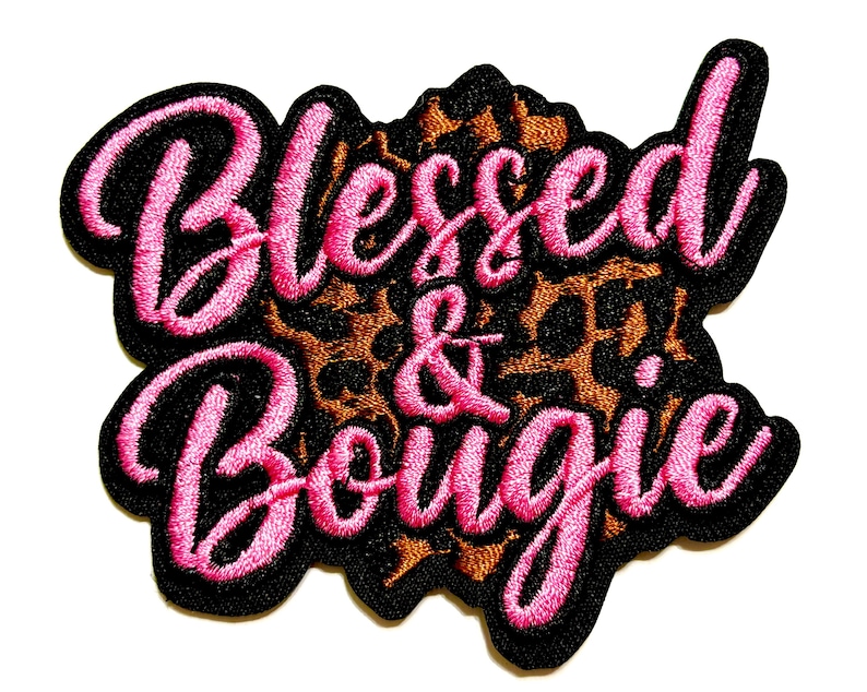 May include: Embroidered patch with the words "Blessed & Bougie" in pink script lettering. The text is outlined in black and set against a leopard print background. The patch has a black border.
