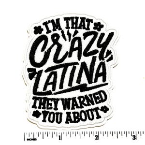 May include: Embroidered patch with the text "I'M THAT CRAZY LATINA THEY WARNED YOU ABOUT" in black script on a white background. The patch is approximately 3 inches wide and 3 inches tall.