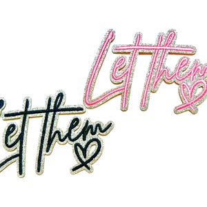 May include: Two embroidered patches with the phrase "Let them". One patch is black with a silver outline and a heart. The other is pink with a silver outline and a heart.