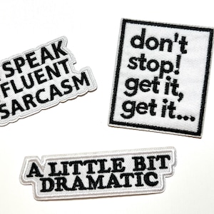 May include: Three embroidered patches with black text on a white background. The patches read: "I SPEAK FLUENT SARCASM", "don't stop! get it, get it...", and "A LITTLE BIT DRAMATIC". Each patch has a black border.
