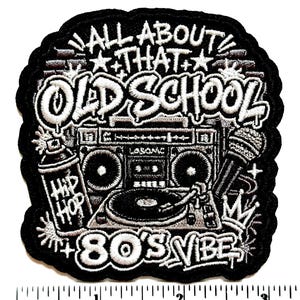 May include: A black and white embroidered patch featuring a boombox, a turntable, a microphone, and a spray paint can labeled Hip Hop. The text reads All About That Old School 80's Vibe. A ruler at the bottom shows the patch is 3 inches wide.