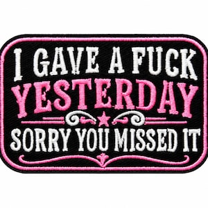 May include: A rectangular embroidered patch with a black background and a pink border. The text reads I GAVE A FUCK YESTERDAY in white and pink, and SORRY YOU MISSED IT in white. Decorative pink and white scrollwork and a star are centered.
