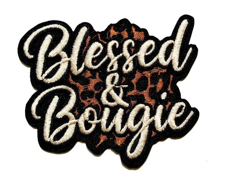 May include: Embroidered patch with the words "Blessed & Bougie" in a cursive font. The text is in off-white thread, outlined in black, and set against a leopard print background.