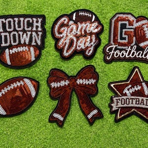 May include: Six decorative patches featuring maroon and white sequins. Designs include a football, a bow, a star, and text reading TOUCH DOWN, Game Day, and GO Football. Each patch has a dark border and is arranged on a bright green textured surface.