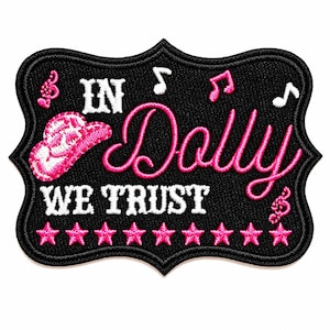 May include: A black embroidered patch with a scalloped edge featuring the white text IN WE TRUST and the pink cursive text Dolly. The design includes a pink cowboy hat, pink and white musical notes, and a row of eight pink stars at the bottom.