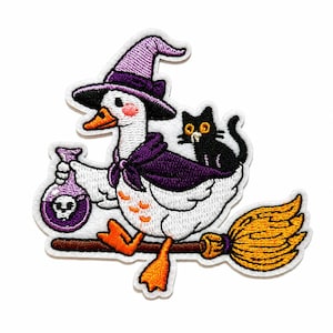 May include: An embroidered patch featuring a white goose wearing a purple witch hat and cape, riding a brown broomstick. The goose holds a purple potion bottle with a skull icon, while a small black cat with yellow eyes sits on its back.
