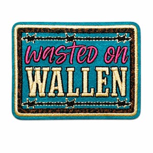 May include: A rectangular embroidered patch with a turquoise background and a brown border. The text "wasted on" is stitched in pink, and the word "WALLEN" is stitched in cream. A black barbed wire design borders the central text area.