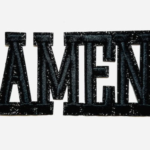 May include: Black glitter-covered patch spelling "AMEN". The letters are thick and blocky, with a textured appearance. The patch is approximately 2 inches in height.