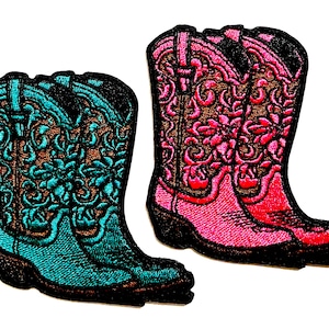 May include: Two embroidered patches of cowboy boots. One boot is turquoise with brown and black accents, the other is pink with brown and black accents. Both have decorative floral patterns.