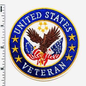 May include: Embroidered patch featuring a bald eagle with outstretched wings, flags, and stars. The patch has a blue border with the words "UNITED STATES VETERAN" in white. Gold stars and a yellow border complete the design.