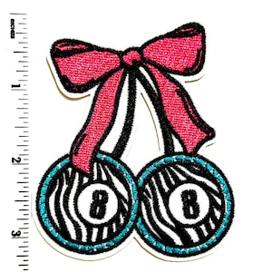 May include: Embroidered patch featuring a pair of cherries with zebra-striped pool balls. The cherries are connected by black stems and a bright pink bow. Each pool ball has a turquoise border and the number 8.