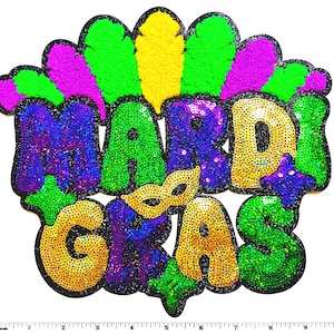 May include: A sequined Mardi Gras patch in green, purple, gold, and yellow. The patch features the words "MARDI GRAS" in large, bubbly letters, with a small gold mask in the center. The patch is outlined in black.