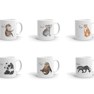 Könnte beinhalten: Sechs weiße Keramikbecher mit verschiedenen Tierillustrationen und aufgedruckten Namen. Die Tiere sind ein Affe, ein Koala, ein Tiger, ein Panda, ein Faultier und ein Panther.