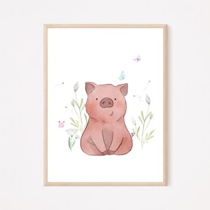 以下が含まれることがあります： 座っているピンクの子豚の水彩イラスト。緑の植物、白い花、蝶に囲まれています。フレームは明るい色の木材で作られています。