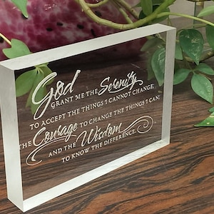 May include: A clear acrylic block with the text "God grant me the serenity to accept the things I cannot change; the courage to change the things I can; and the wisdom to know the difference." engraved in white.