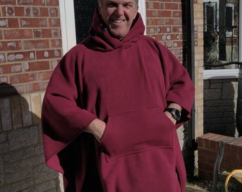 May include: A maroon hooded poncho with a large front pocket. The poncho is made of a soft, fleece-like material.