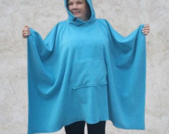 May include: A turquoise blue hooded poncho with a front pocket. The poncho is made of a soft, fleece-like material.