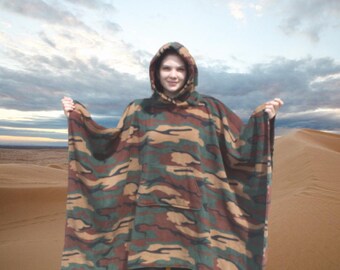 May include: A hooded poncho with a camouflage pattern in shades of brown, green, and tan. The poncho has a large pocket on the front and a drawstring hood.