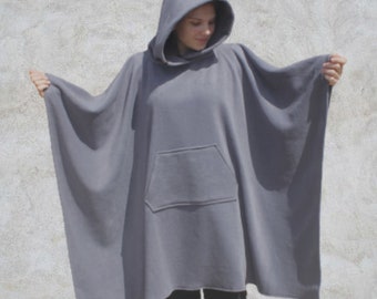 May include: A grey hooded poncho with a large pocket on the front. The poncho is made of a soft, fleece-like material.
