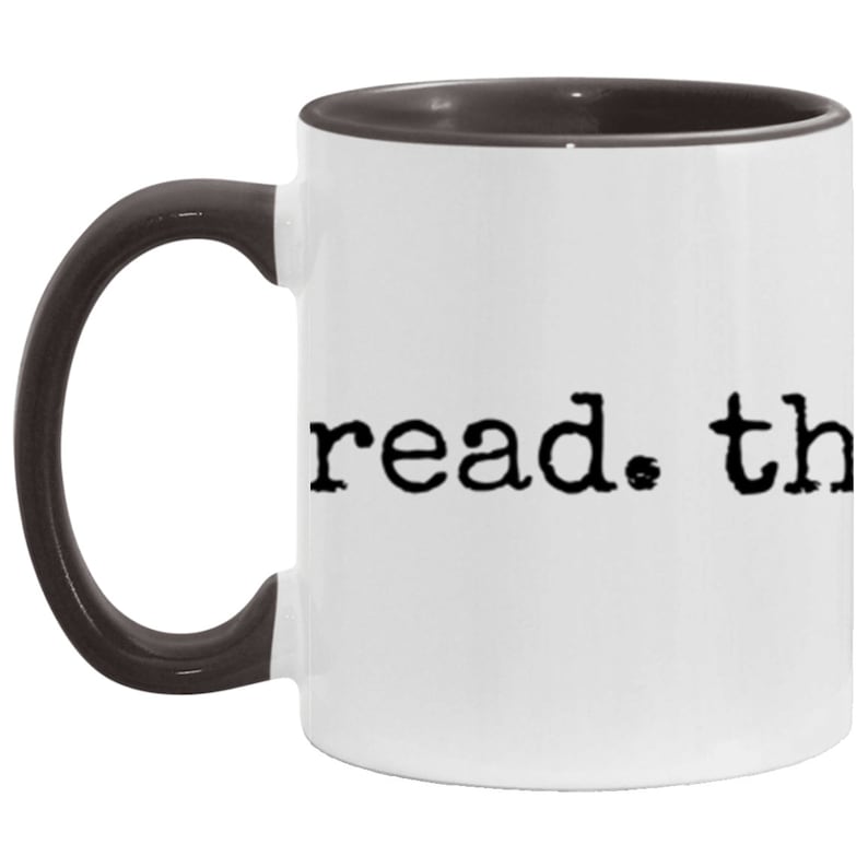 May include: White ceramic coffee mug with a black interior and handle. The mug has the text "read. the" printed in black on the front.