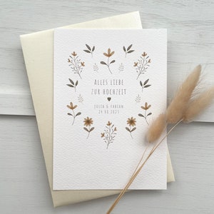 May include: A white card with a floral design and the text "Alles Liebe zur Hochzeit" with the date "July 08, 2023" and the names "Julia & Fabian".