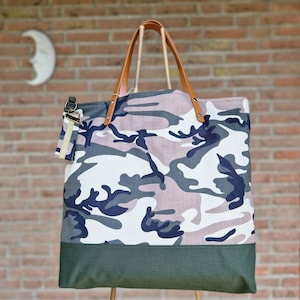Bolso tote con forro de camuflaje y rayas de cuero, soporte para tus llaves y bolsillos profundos para guardar tu billetera, teléfono y gafas de sol.