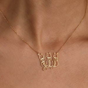 Pu&ograve; includere: Collana in oro con tre silhouette di gatti, ciascuna con un nome inciso: Luna, Daisy e Pippy.