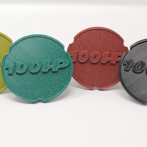 Könnte beinhalten: Vier kreisförmige Objekte in Grün-, Rot- und Schwarztönen, jeweils mit dem Text "100HP" geprägt. Die Objekte haben eine strukturierte Oberfläche und eine Kerbe auf einer Seite.