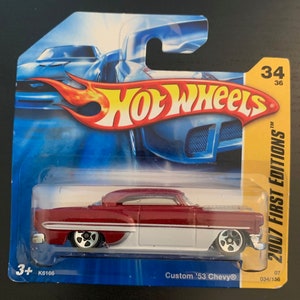 Peut inclure: Une voiture Hot Wheels Chevrolet 1953 rouge et blanche dans un emballage en plastique. L'emballage est bleu et jaune et porte le logo Hot Wheels ainsi que le texte "2007 First Editions".