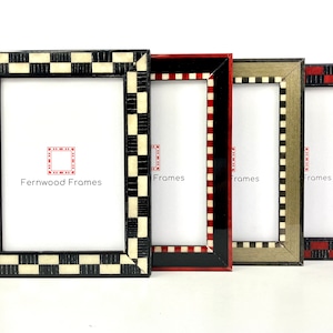 May include: Four picture frames with black, red, and gray checkered borders. The frames are arranged from left to right with the largest frame on the left and the smallest frame on the right. The frames are all made of wood and have a glossy finish. The text "Fernwood Frames" is printed on the largest frame.