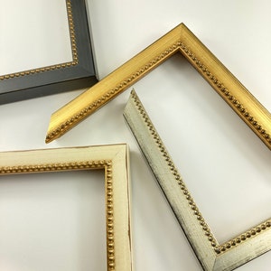 May include: Three picture frames with ornate gold beading. The frames are in different colours: black, white and silver.