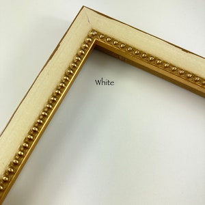 May include: White picture frame with a gold beaded trim. The frame is made of wood and has a simple, classic design.
