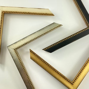 May include: Three picture frames with ornate gold trim and beaded edges. The frames are in different sizes and colours: white, silver, and black.