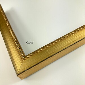 May include: A gold picture frame with a beaded edge. The frame is made of wood and has a matte finish.