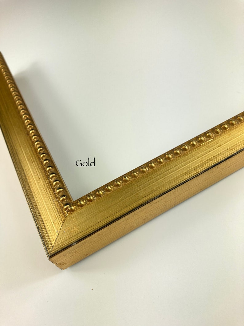 May include: A gold picture frame with a beaded edge. The frame is made of wood and has a matte finish.
