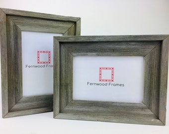 May include: Two rustic wood picture frames with a gray weathered finish. The larger frame has the text "Fernwood Frames" printed on the white mat. The smaller frame has the text "Fernwood Frames" printed on the white mat.