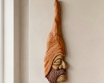 手彫りの木製の顔の彫刻。木の精霊。彫刻された王様。男性。民芸品