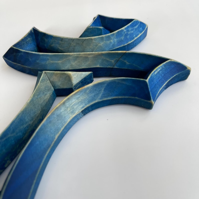 Peut inclure: Sculpture en bois bleu compos&eacute;e de plusieurs pi&egrave;ces courbes. La sculpture est abstraite et ressemble &agrave; une lettre stylis&eacute;e.