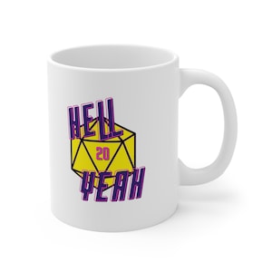 May include: White ceramic mug with a yellow 20-sided die and the text "HELL YEAH" in purple and pink.