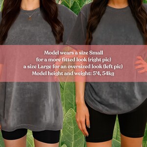 May include: Two women wearing gray t-shirts and black shorts. The text on the image says the model wears a size Small for a fitted look and a size Large for an oversized look. The model's height is 5'4 and weighs 54kg.