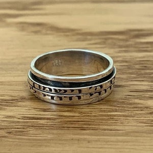 May include: A silver spinning ring with Hebrew text engraved on the band.
