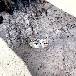 May include: A silver ring with Hebrew text engraved around the band. The text reads "Shema Yisrael Adonai Eloheinu Adonai Echad" which translates to "Hear O Israel, the Lord our God, the Lord is One."