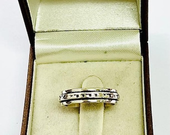 May include: A silver spinning ring with a textured design in a brown velvet ring box.