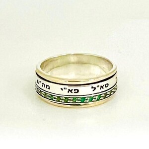 Op de afbeelding: Een draaibare zilveren en gouden ring met groene emaille en Hebreeuwse tekst. De tekst luidt "Say" "Chai" en "Mah Tov"