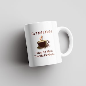 Könnte beinhalten: Weiße Keramiktasse mit einer braunen Illustration einer Tasse Tee und dem Text "Tu Tathi Rahi Saag Ta Main Thanda Hi Khalu".